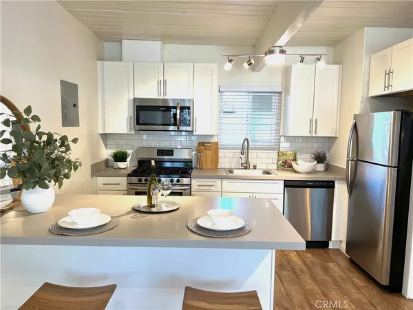 a kitchen with a sink a stove and chairs