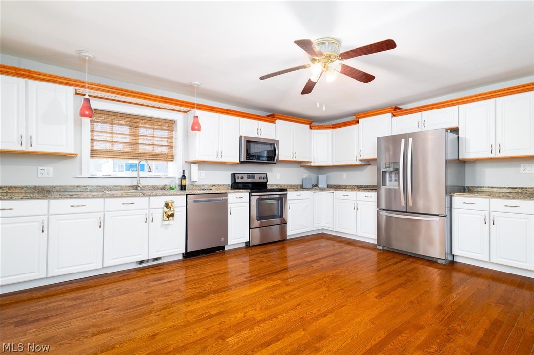 165 9th Street Wellsburg, WV 26070 - Photo 19 of 37 Kitchen with decorative light fixtures, white cabinets, stainless steel appliances, light stone counters, and a ceiling fan