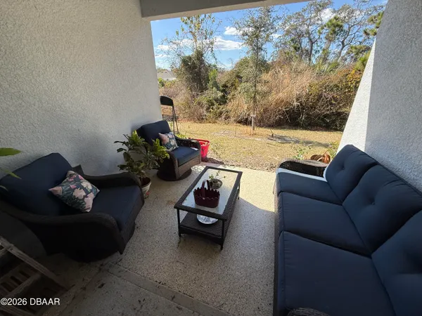 a living room with furniture and a floor to ceiling window