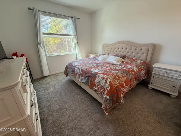 a bed sitting in a bedroom next to a window