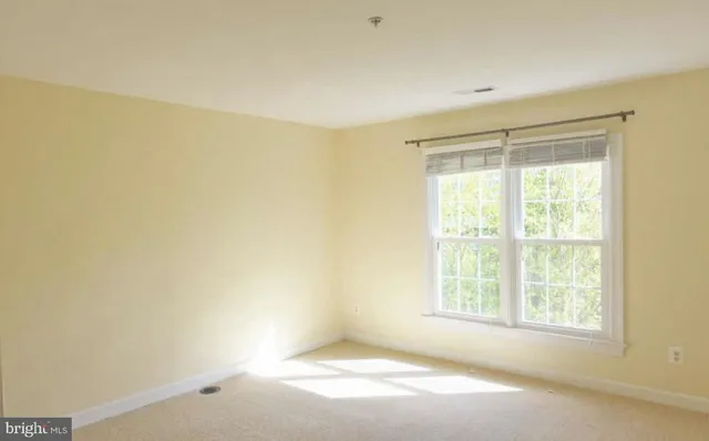 an empty room with windows and fireplace