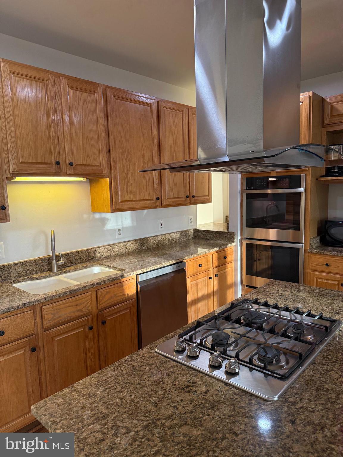 1847 Brenthill Court Vienna, VA 22182 - Photo 6 of 26 a kitchen with a stove a sink and a cabinets