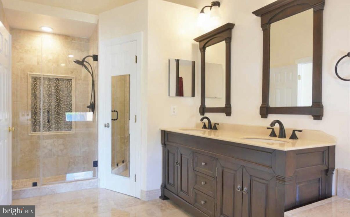 1847 Brenthill Court Vienna, VA 22182 - Photo 10 of 26 a bathroom with a double vanity sink mirror and shower