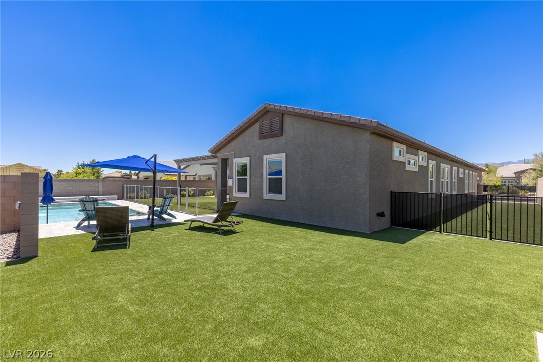7036 Arabian Ridge Street Las Vegas, NV 89131 - Photo 49 of 64 Low maintenance turf backyard with plenty of space and an enclosed dog run.