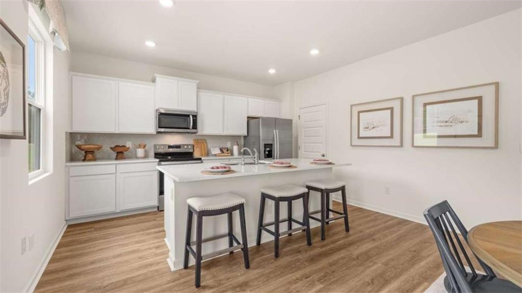 330 Friendship Oak Way Hampton, GA 30228 - Photo 8 of 41 a kitchen with stainless steel appliances granite countertop a stove a sink a microwave a island with a dining table and chair
