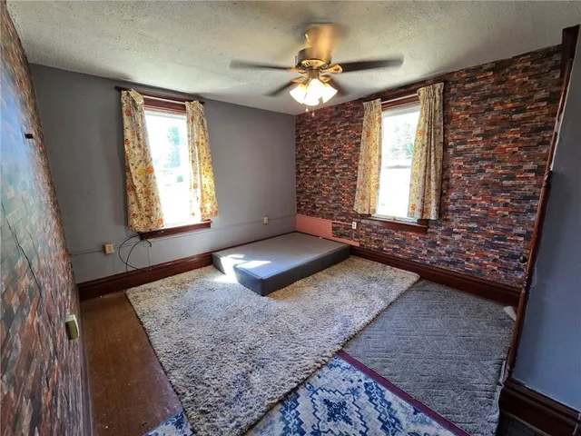 an empty room with windows and fireplace