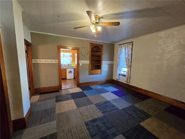 a view of a hallway with wooden floor and a ceiling fan