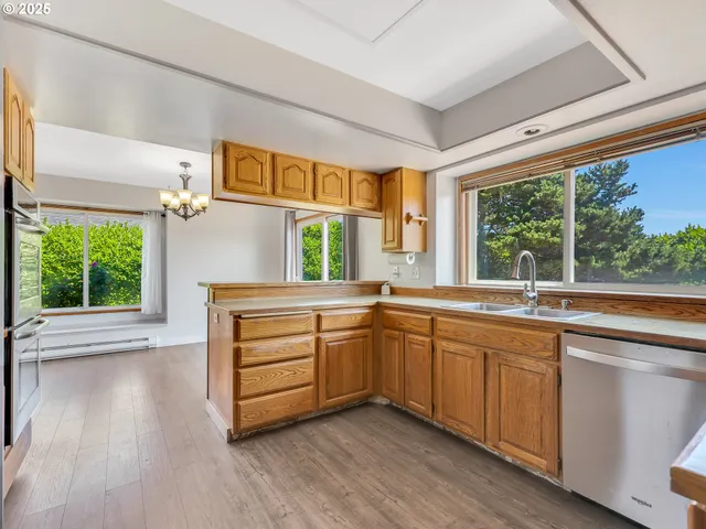 a kitchen with a sink window and wooden floor