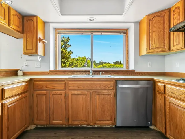 a kitchen with stainless steel appliances granite countertop a sink and a window