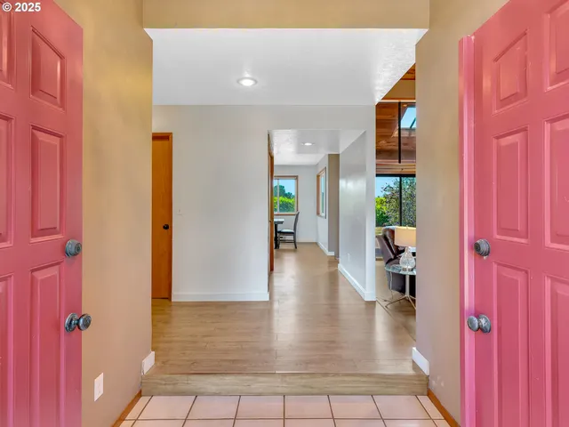 a view of a hallway with wooden floor and a living room