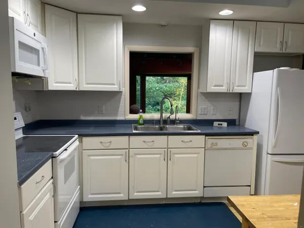 a kitchen with white cabinets and white appliances