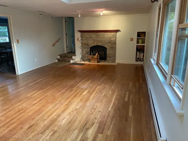 a view of a livingroom with wooden floor and a fireplace