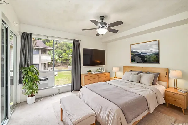 a bedroom with a balcony a bed and a flat screen tv