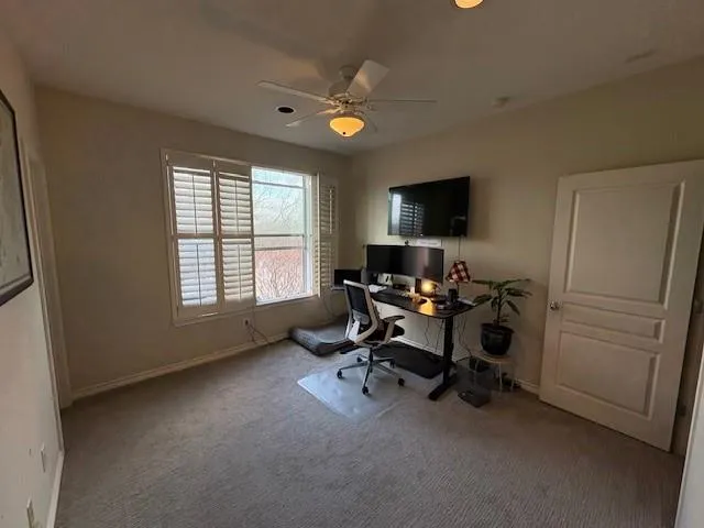a view of a workspace with furniture and a window
