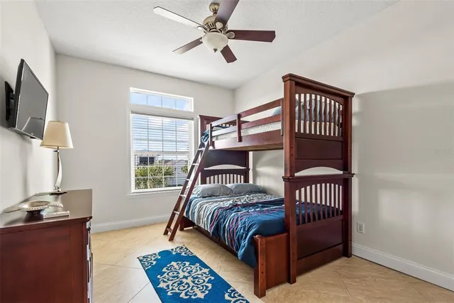 a bedroom with a bed window and a flat screen tv