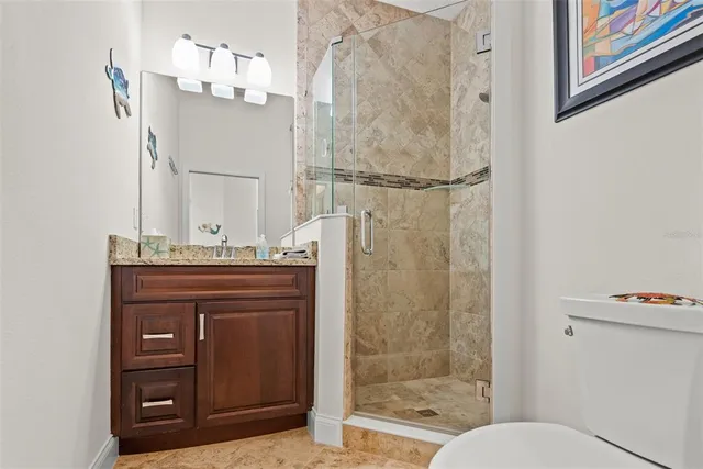 a bathroom with a granite countertop sink a mirror and a shower