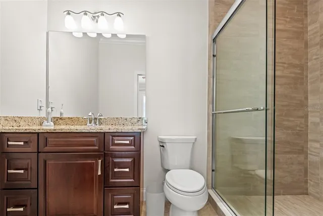 a bathroom with a granite countertop sink toilet and shower
