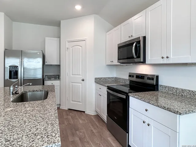 a kitchen with stainless steel appliances granite countertop a stove a microwave and refrigerator