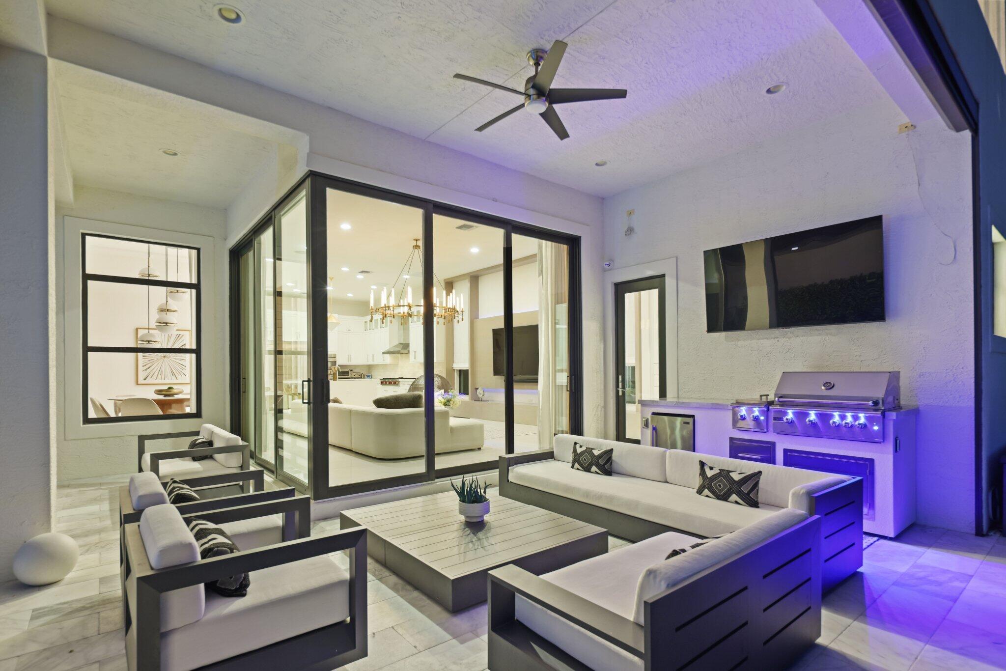 9276 Biaggio Road Boca Raton, FL 33496 - Photo 68 of 70 a living room with furniture a flat screen tv and a large window