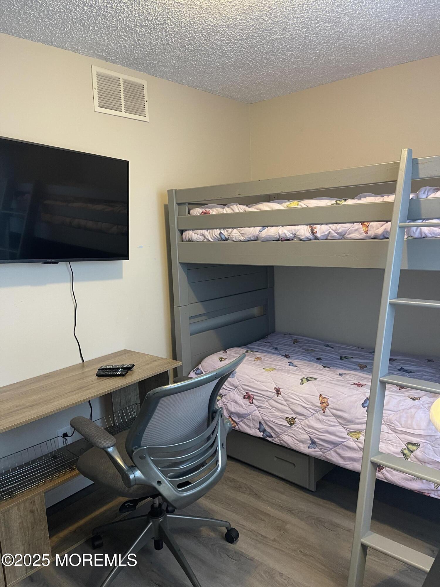 202 Carteret Avenue, Unit A2 Seaside Heights, NJ 08751 - Photo 13 of 15 a bedroom with a bed and a flat tv screen