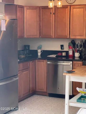 a kitchen with stainless steel appliances granite countertop a refrigerator a stove and a sink