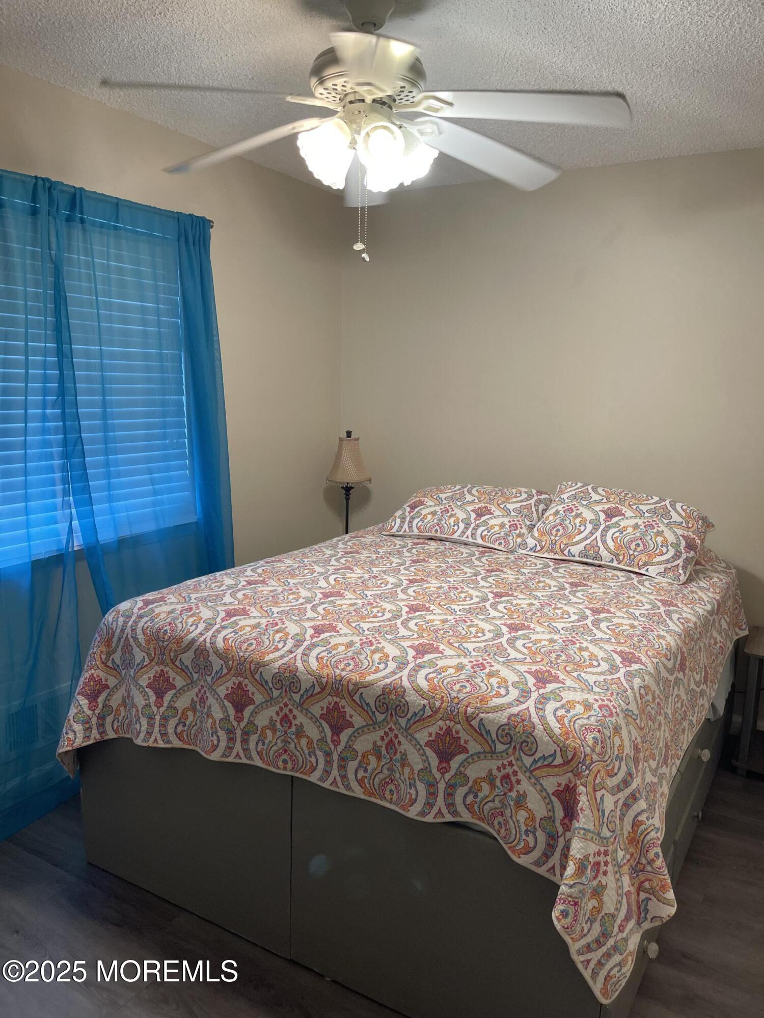 202 Carteret Avenue, Unit A2 Seaside Heights, NJ 08751 - Photo 8 of 15 a bedroom with a bed and a chandelier