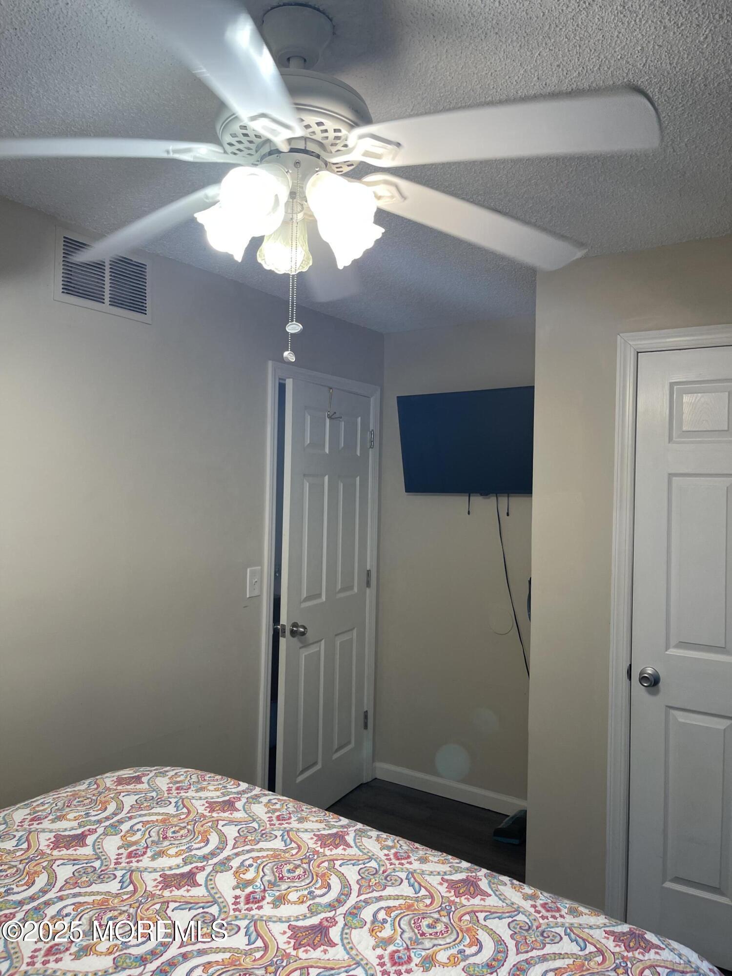 202 Carteret Avenue, Unit A2 Seaside Heights, NJ 08751 - Photo 9 of 15 a bedroom with a bed and a chandelier