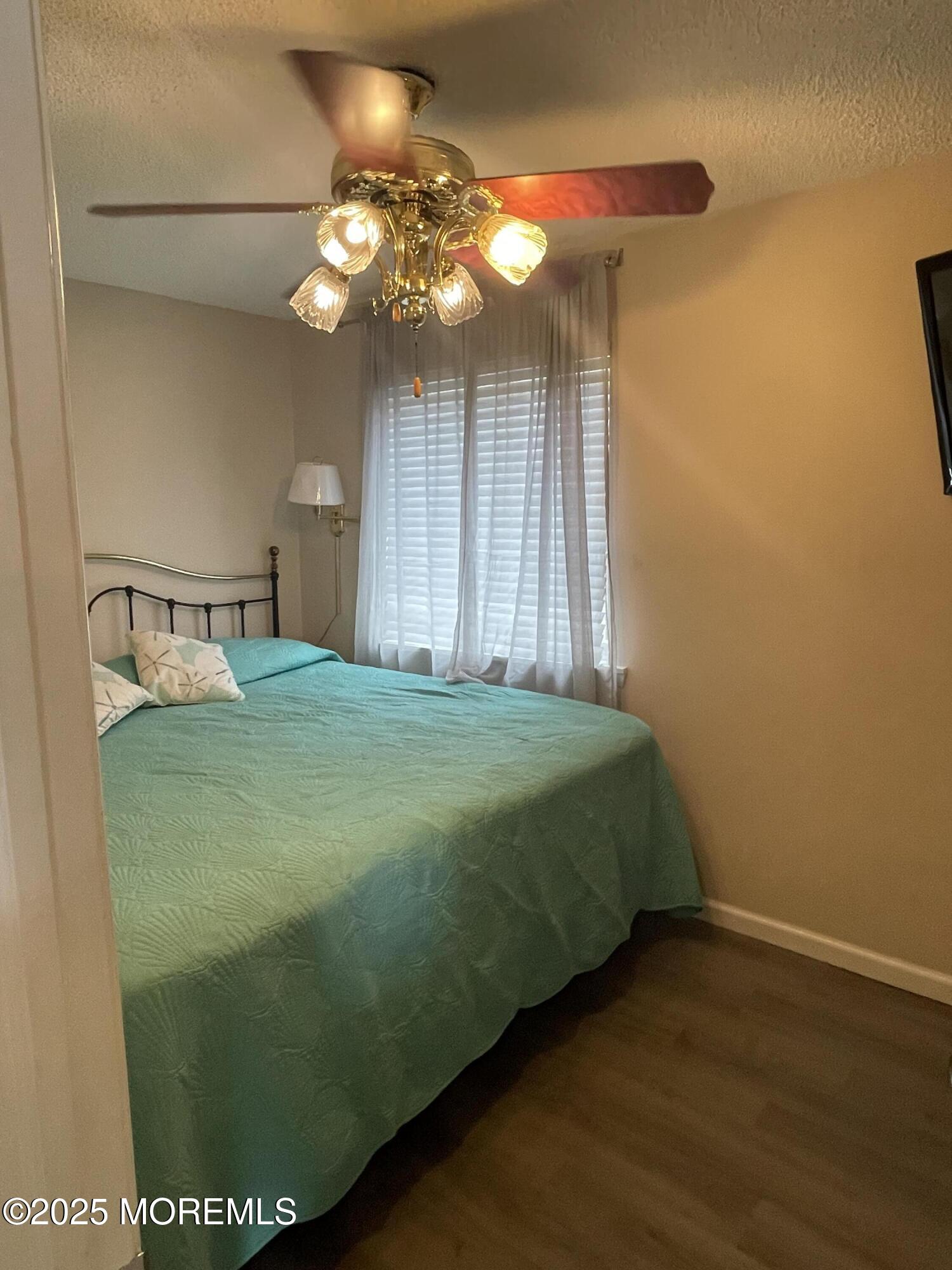 202 Carteret Avenue, Unit A2 Seaside Heights, NJ 08751 - Photo 10 of 15 a bedroom with a bed and a chandelier