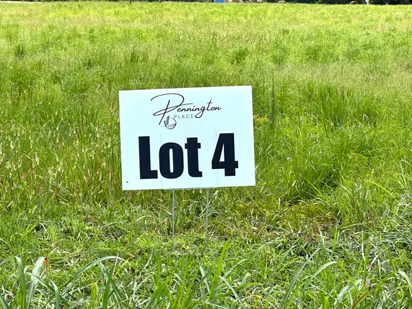 a sign of golf club on a wall under a tree
