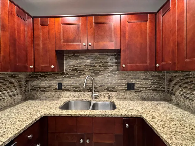 a kitchen with stainless steel appliances granite countertop wooden cabinets a sink and dishwasher