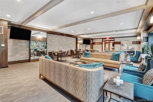a living room with furniture flat screen tv and couches