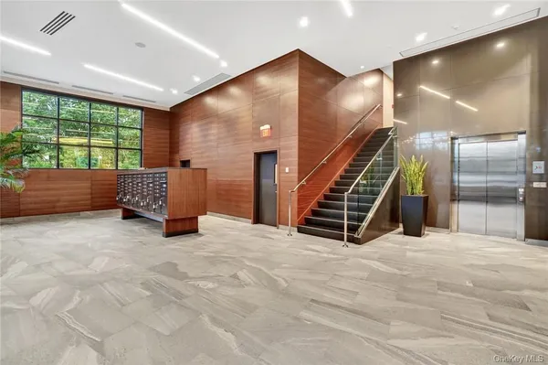 a view of an empty room with stairs and furniture