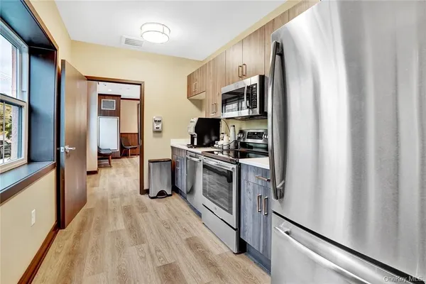 a kitchen with stainless steel appliances a refrigerator and a stove top oven