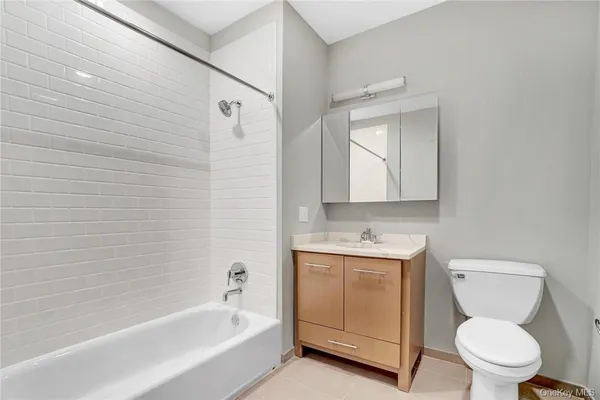 a bathroom with a toilet a sink a mirror and bathtub