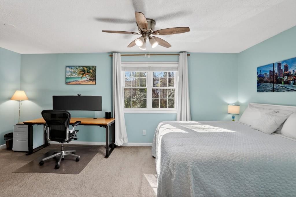 6900 Roswell Road, Unit L7 Atlanta, GA 30328 - Photo 21 of 25 a bedroom with a bed a desk and a chandelier