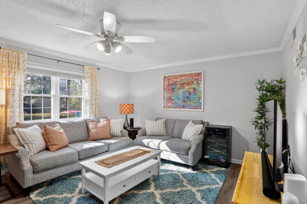 6900 Roswell Road, Unit L7 Atlanta, GA 30328 - Photo 3 of 25 a living room with furniture a large window and a flat screen tv