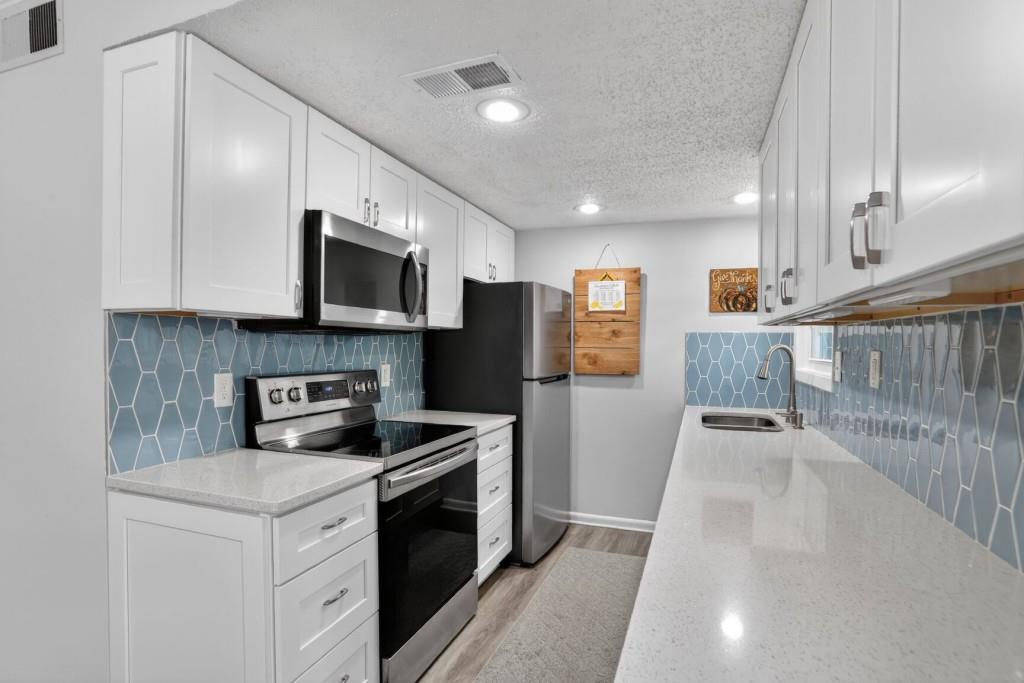 6900 Roswell Road, Unit L7 Atlanta, GA 30328 - Photo 7 of 25 a kitchen with stainless steel appliances granite countertop a stove a sink and a refrigerator