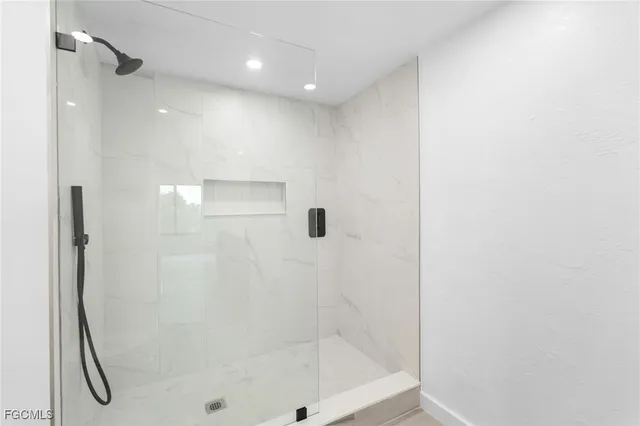 a bathroom with a shower and a glass door