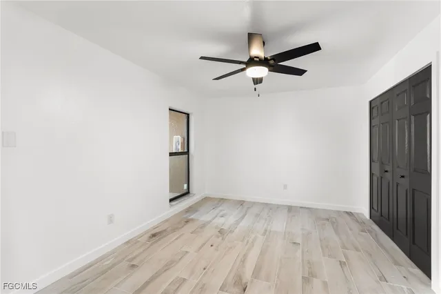 an empty room with wooden floor a ceiling fan and closet