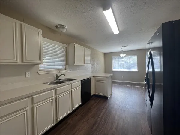 a kitchen with a white cabinets sink and window