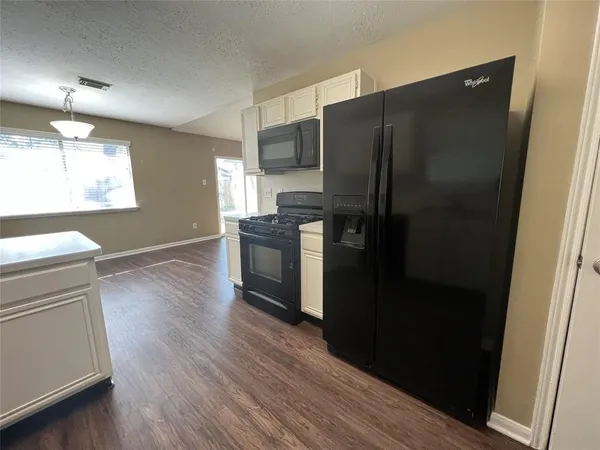 a kitchen with a refrigerator and a stove