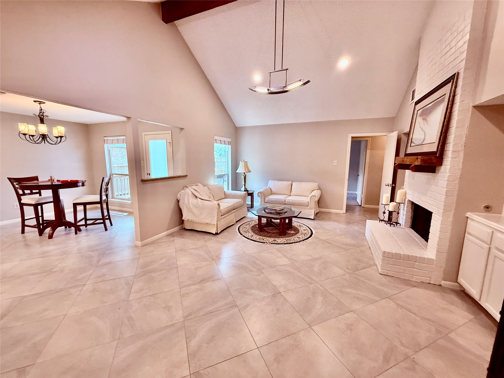 13 Maywind Court The Woodlands, TX 77381 - Photo 2 of 33 Step inside to fresh 2026 interior paint, neutral finishes & large-format porcelain tile. Note the open sight lines connect the family room, dining area & kitchen for a comfortable flow.