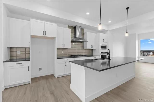 a kitchen with kitchen island a sink stainless steel appliances and white cabinets