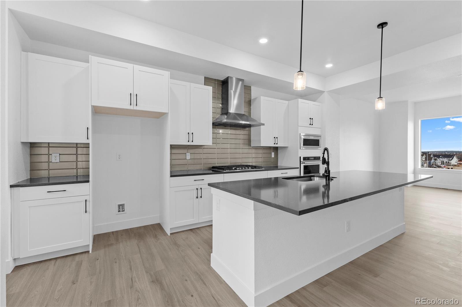 14281 Currant Street Broomfield, CO 80020 - Photo 11 of 23 a kitchen with kitchen island a sink stainless steel appliances and white cabinets