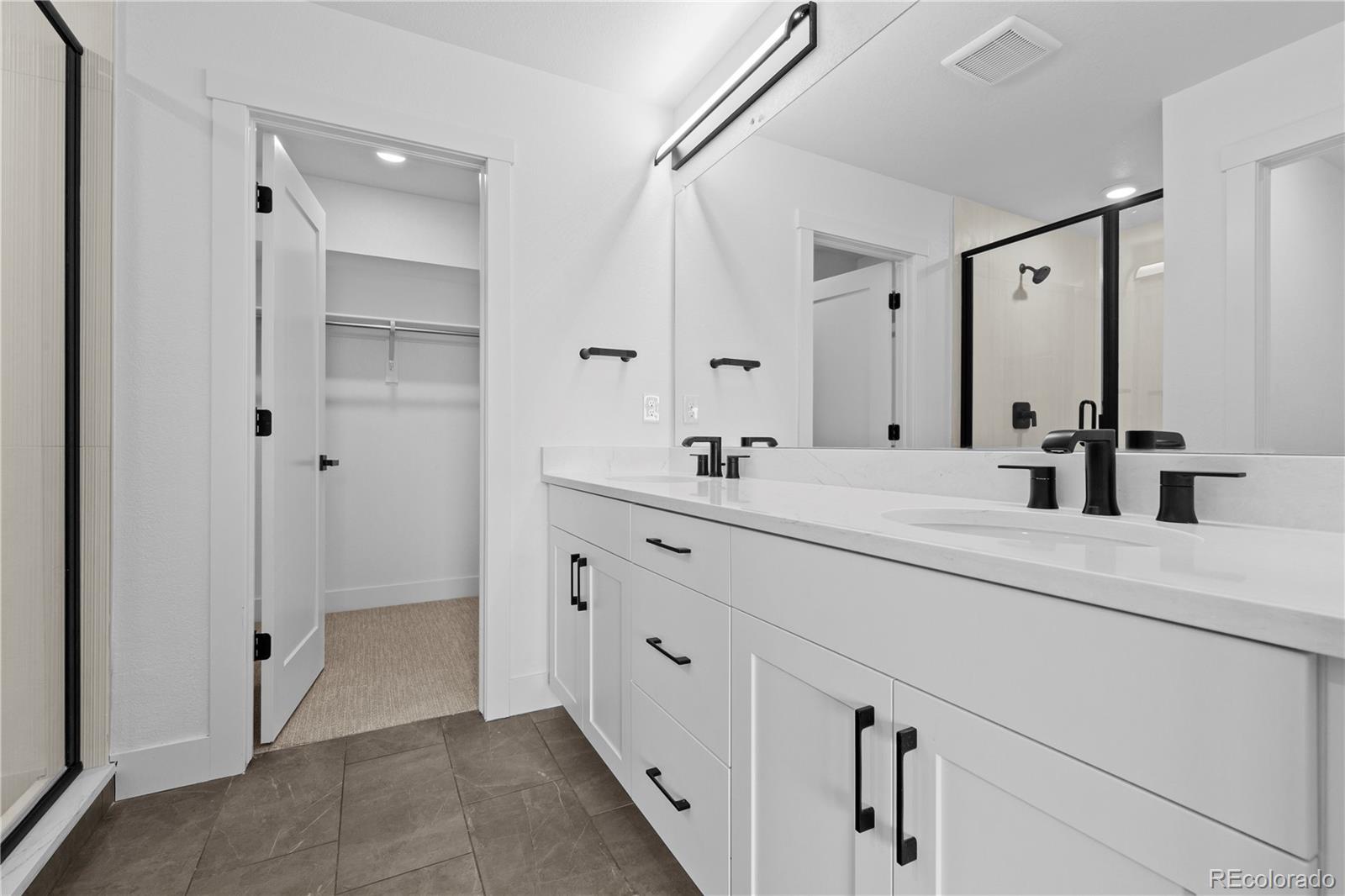 14281 Currant Street Broomfield, CO 80020 - Photo 21 of 23 a spacious bathroom with a double vanity sink mirror and shower