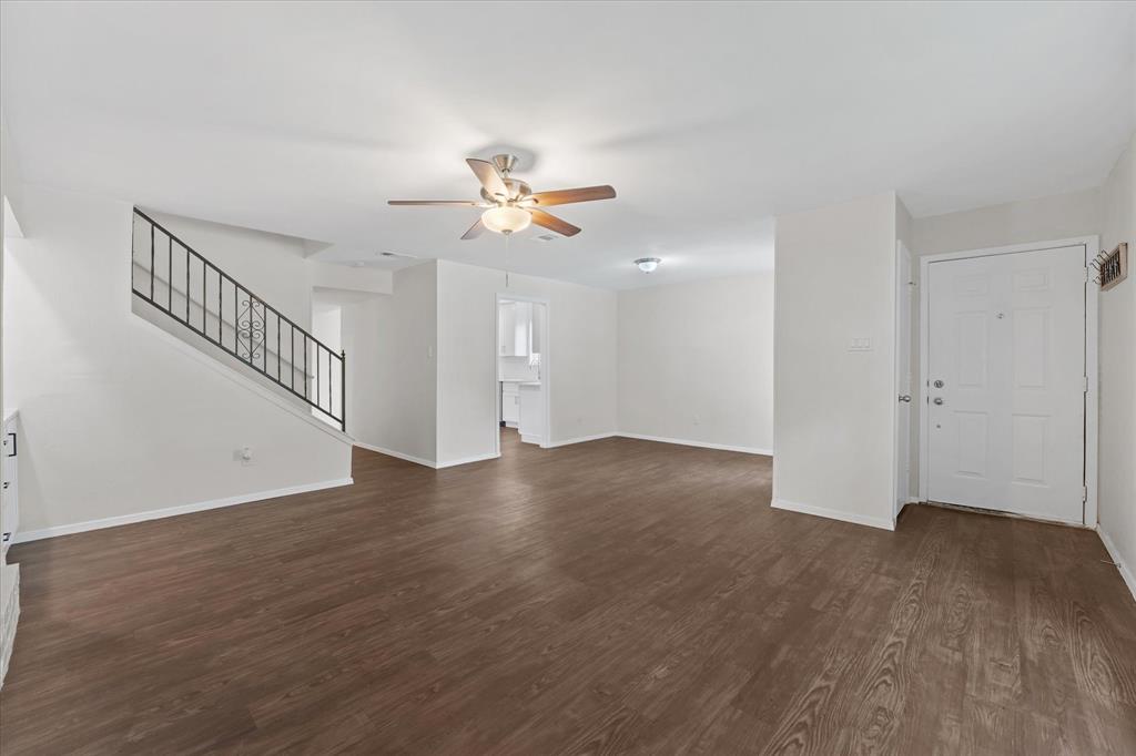 4007 Ridgebrook Drive Arlington, TX 76015 - Photo 5 of 18 Spacious living area featuring wood-finish flooring, a ceiling fan with integrated lighting, and a white paneled entry door
