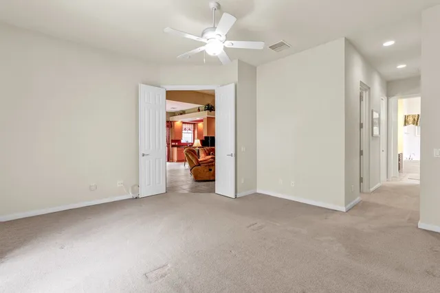 an empty room with closet and a ceiling fan