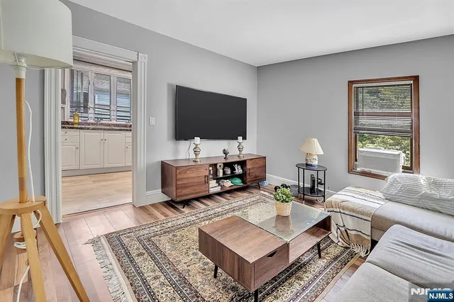 a kitchen with a stove a sink and wooden floor