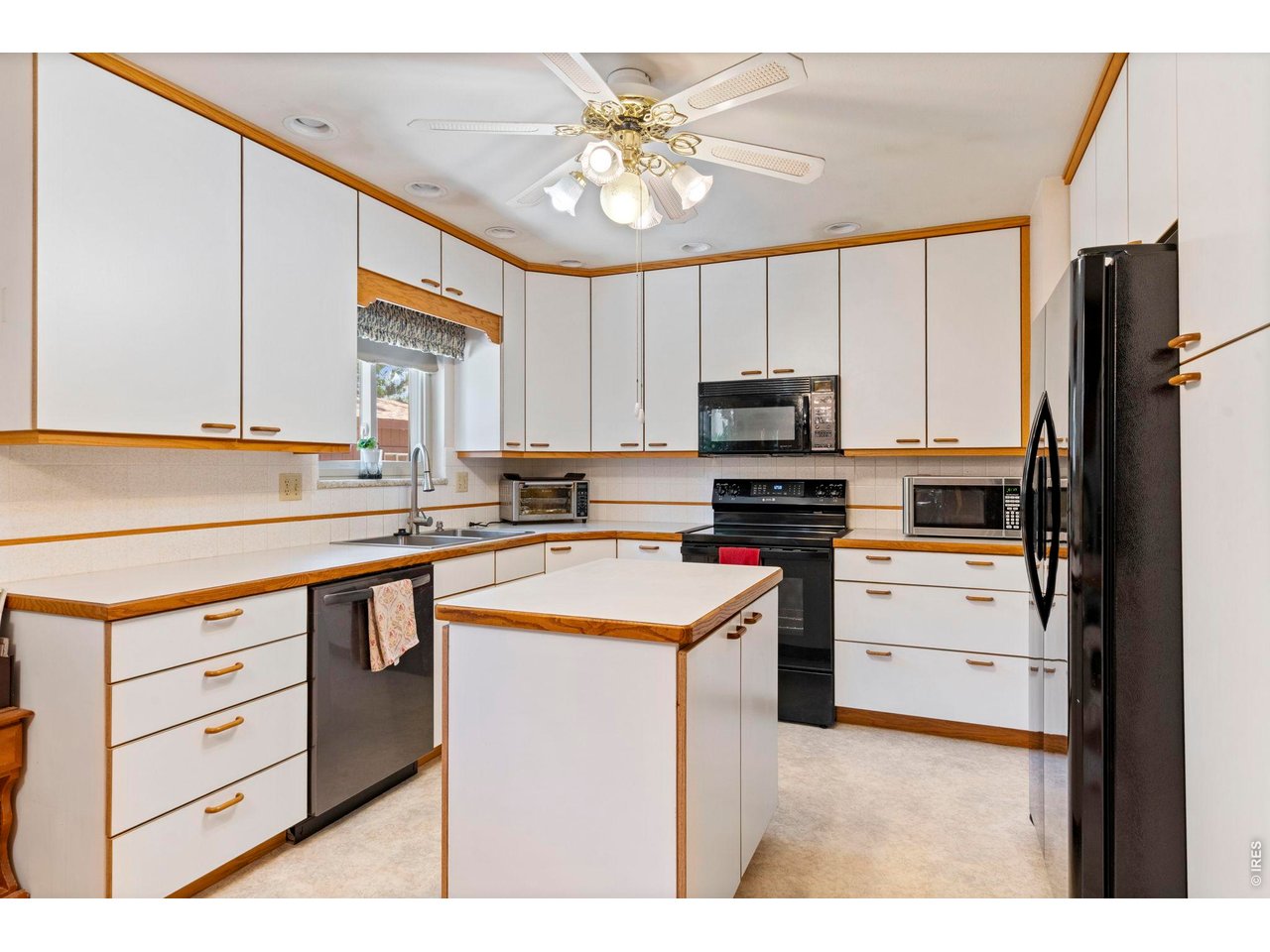 300 Ranch Acres Drive Loveland, CO 80538 - Photo 9 of 38 a kitchen with a stove a sink and a refrigerator