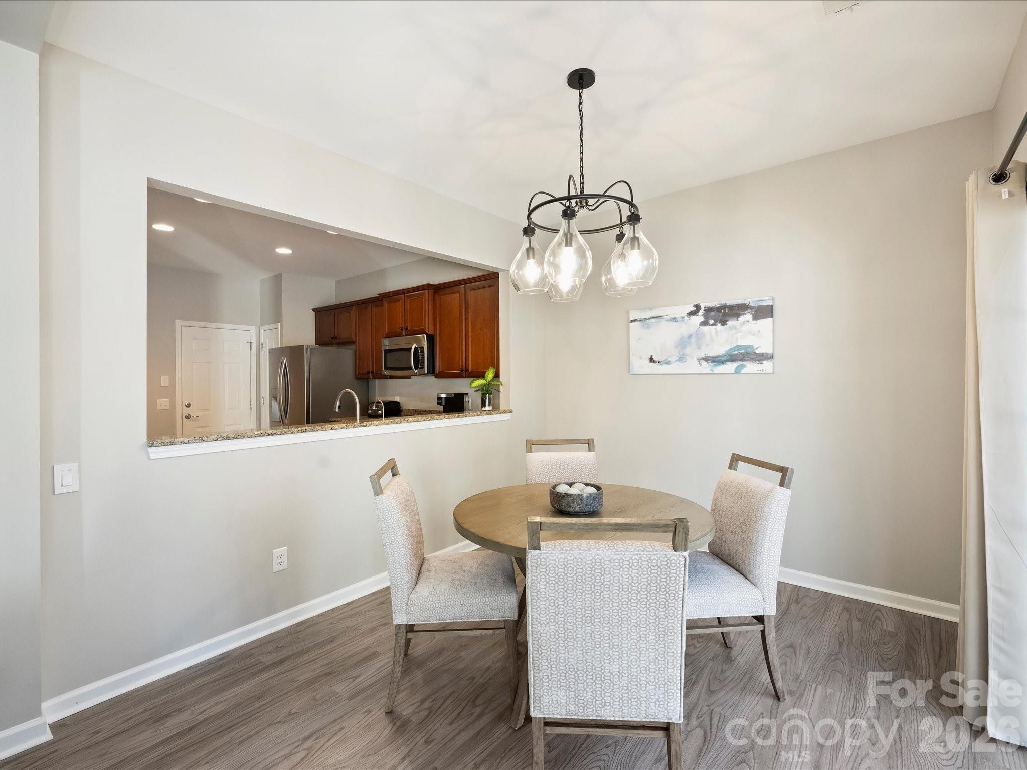15544 Canmore Street Charlotte, NC 28277 - Photo 11 of 36 a view of a dining room with furniture wooden floor kitchen and chandelier